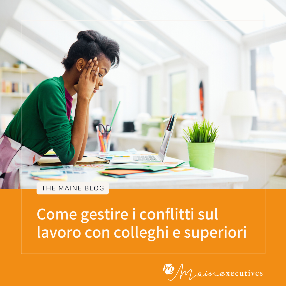 Come gestire i conflitti sul lavoro - Donna stressata davanti al computer in ufficio con documenti sparsi sulla scrivania