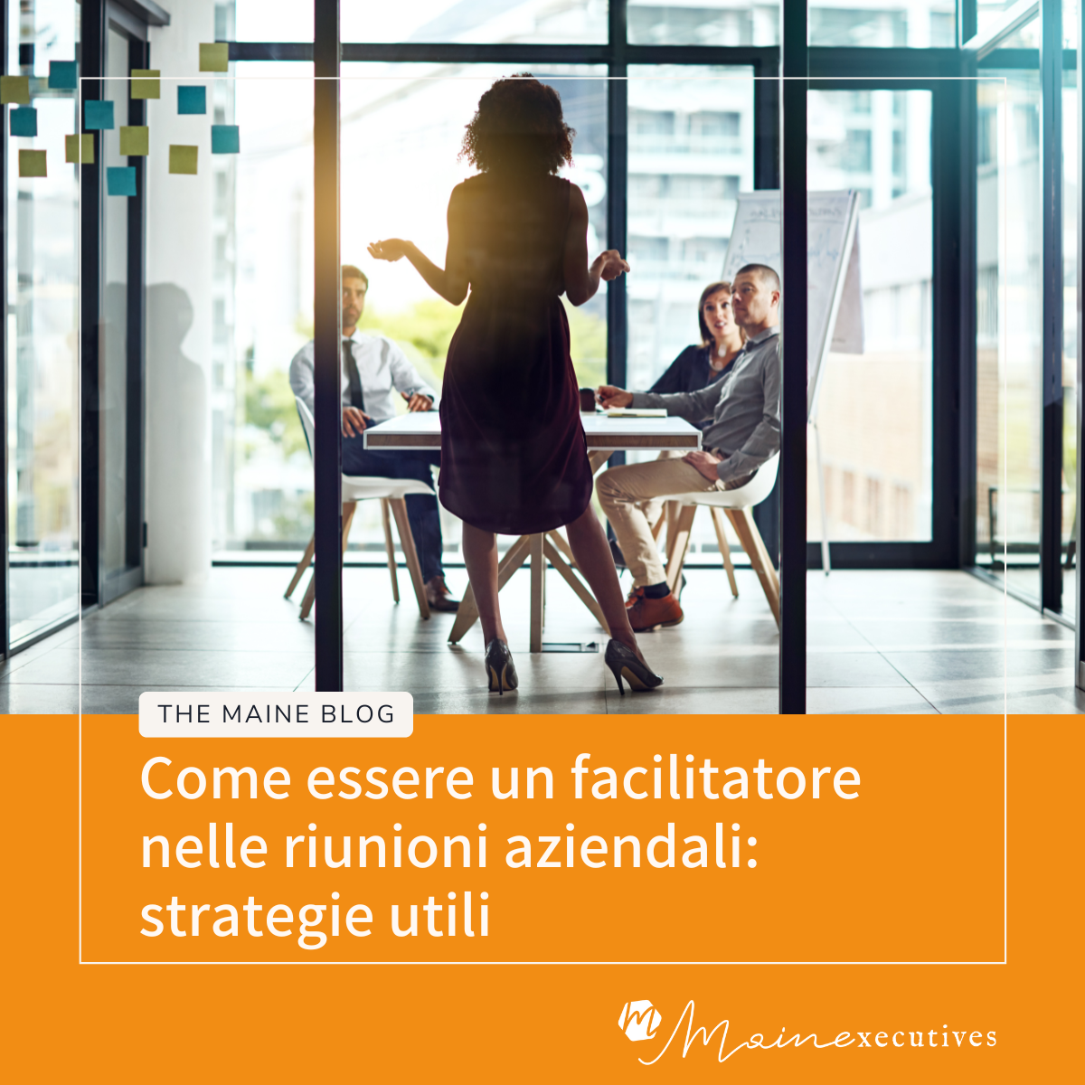 L'Assistente come facilitatore delle riunioni aziendali - Donna in piedi conduce una riunione con tre colleghi seduti attorno a un tavolo