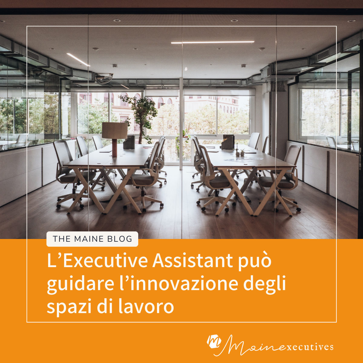 Open space moderno in azienda con scrivanie e sedie su ruote, pareti vetrate e grandi finestre